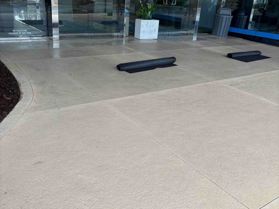 Clean concrete at glass front entrance doors of commercial building in Feather Sound, Clearwater, FL
