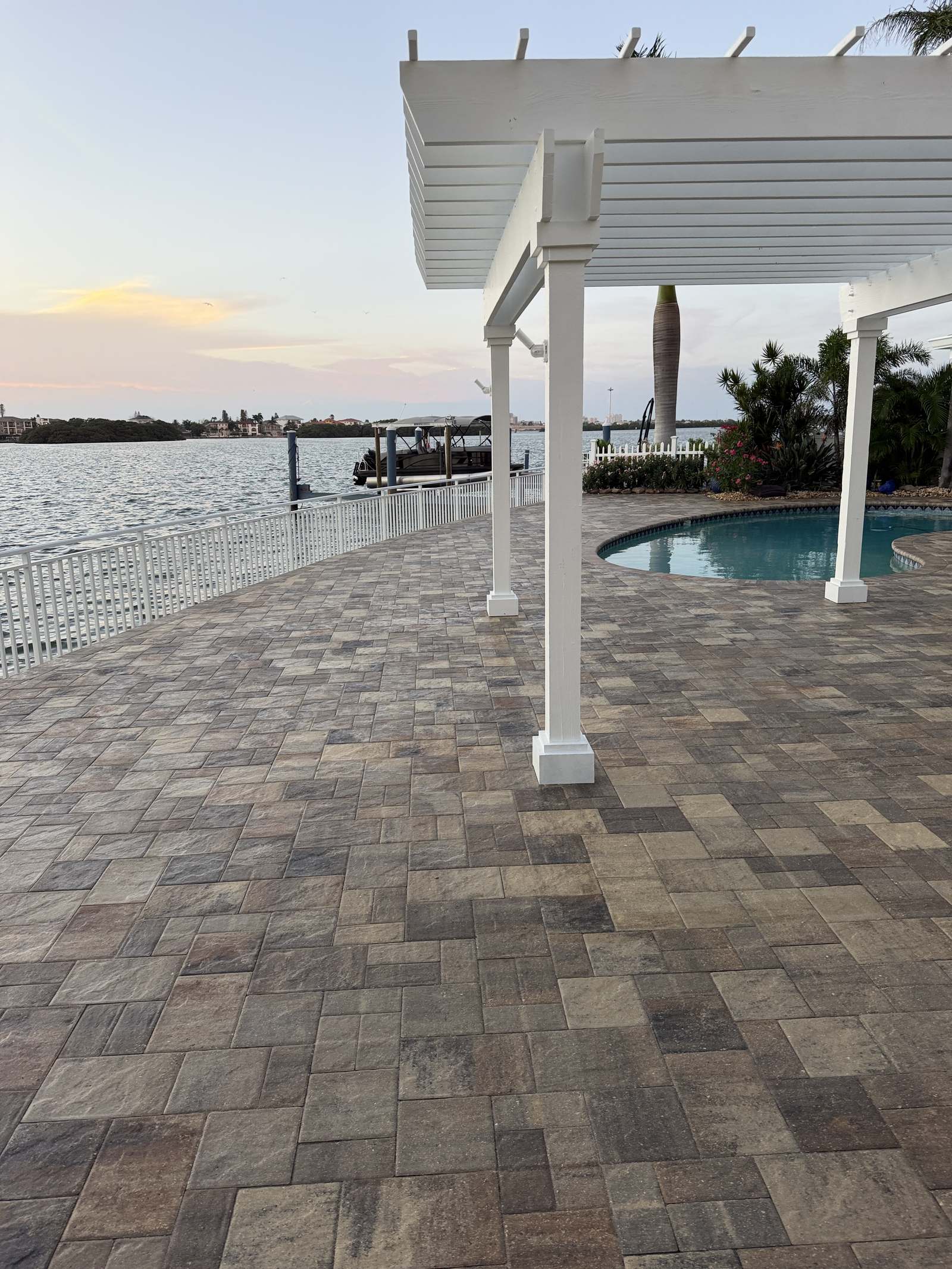Sealed paver waterfront patio with pergola and dock view in Indian Rocks Beach, FL
