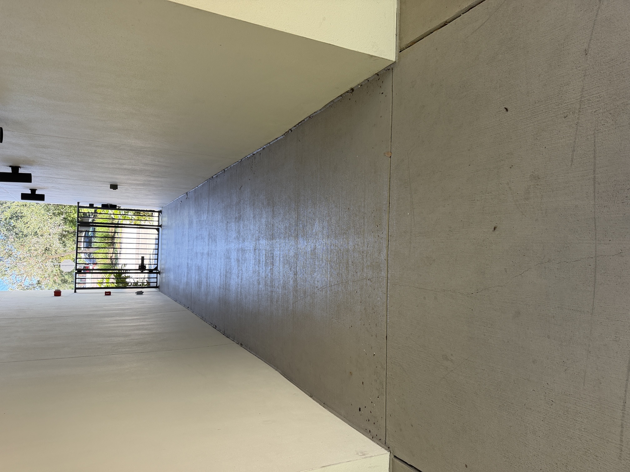 Before photo of a covered breezeway leading to a gated walkway at an apartment community in Largo, FL