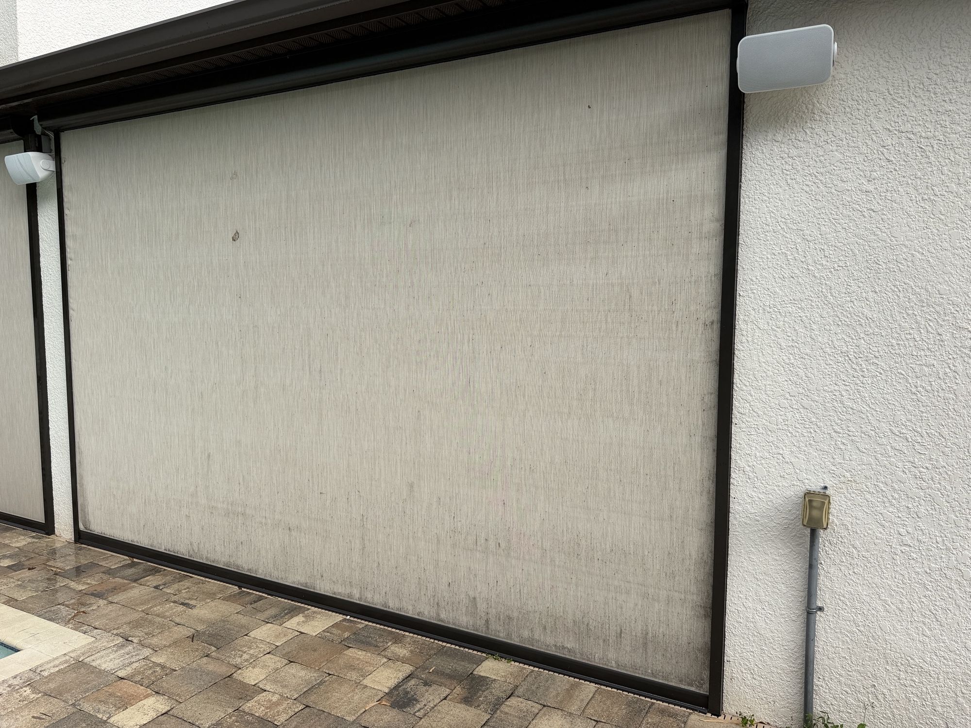 Before photo of a dirty, mildew-streaked lanai screen panel near Brandon