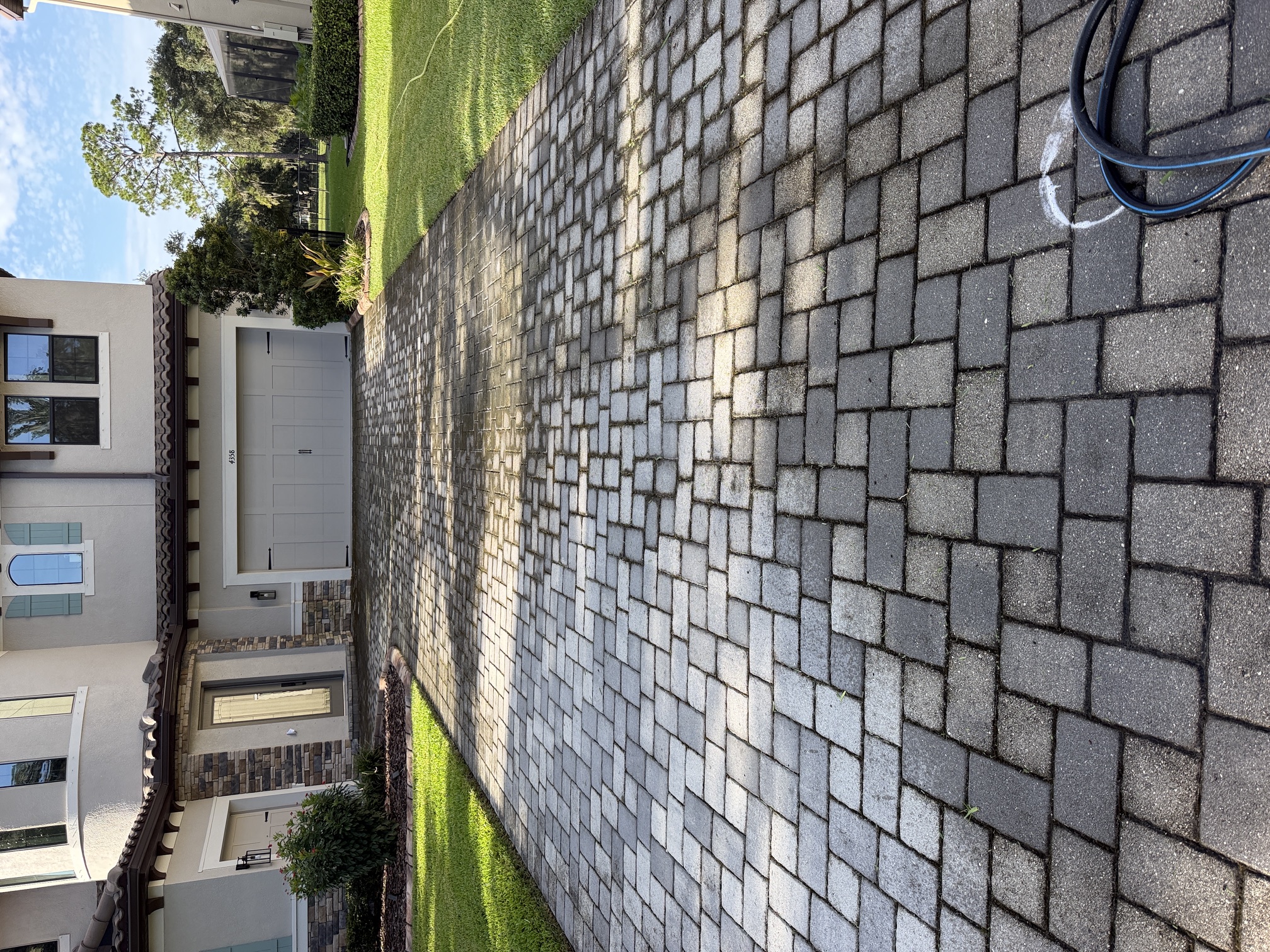 Before photo of a driveway with heavy algae staining in The Sanctuary, Brandon, FL