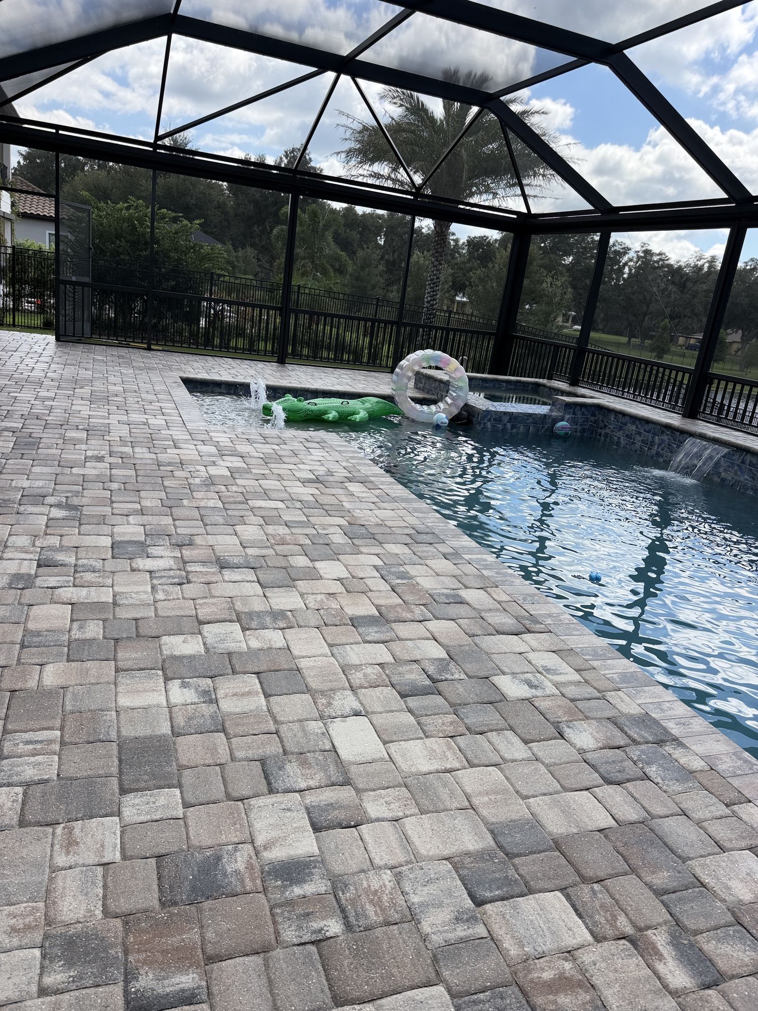 Sealed pool deck pavers near the spa and waterfall at the first home in The Sanctuary, Brandon, FL